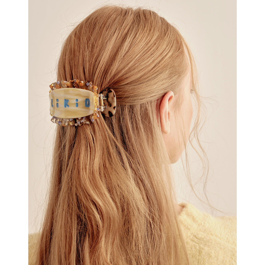 Pince plate Likio bordée de dentelle portée dans une coiffure à moitié attachée