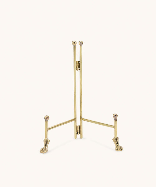 Gold tone foldable Doing Goods brass display stand with small lion feet, front view