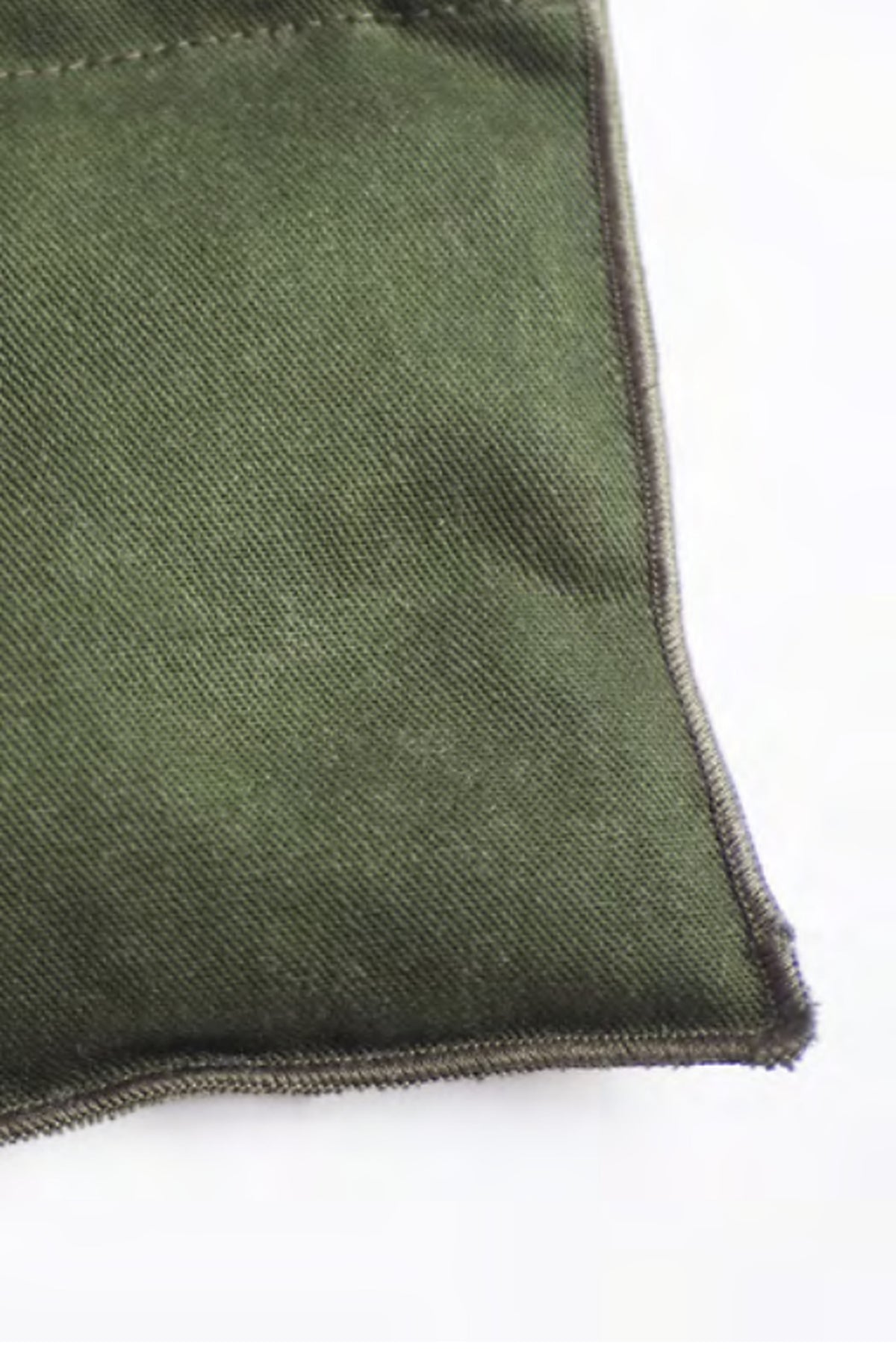 Detail van de hoek en stiksels van de kaki onderzetter met kersenpitten van Ensemble